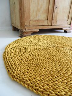 a yellow rug on the floor next to a wooden cabinet