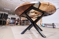 a wooden table sitting on top of a white tiled floor next to a pile of wood