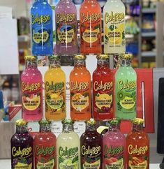 many bottles of juice are stacked on top of each other in front of a store display