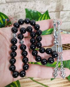 "✔️ This is a 33 pcs attractive tasbih made of AAA quality 10 mm shining black onyx beads. ✔️ It is a elegant and striking rosary. ✔️ This black ONYX tesbih is made from using Genuine Natural Onyx Stone NOT GLASS ONYX.. ✔️ Bead Size: 10 mm ✔️ Gemstone: Original Black Onxy ✔️ Total lenght: 32 cm (12.59 inches) ✔️ Each order comes in a special box. ✔️ PLEASE CLICK THE LINK FOR ALL PRAYER BEADS MODELS https://www.etsy.com/shop/GoodJewelsofYazmasal Note: As a natural feature the stones beads may hav Traditional Black Beads For Gift, Handmade Black Spiritual Beads, Handmade Spiritual Black Beads, Traditional Black Gemstone Beads, Black 8mm Beads For Gifts, Spiritual Black Beads For Jewelry Making, Adjustable Black Rosary With 8mm Beads, Traditional Black Rosary With 8mm Beads, Gift Black Rosary With 8mm Beads