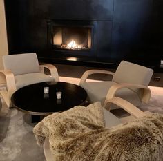 a living room filled with furniture and a fire place in the wall behind the fireplace