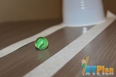 two candy candies sitting on top of a wooden table next to a white cup