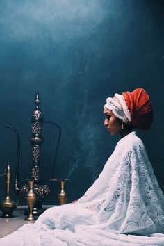 a woman sitting on the floor next to an ornate lamp