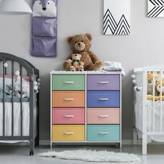 a teddy bear sitting on top of a dresser next to a crib and baby's bed