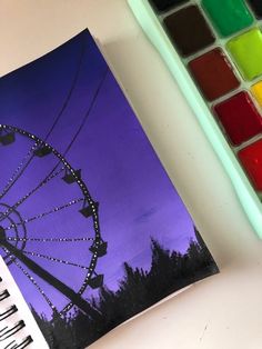 a painting of a ferris wheel next to a watercolor palette