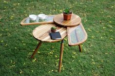 a wooden table with two trays on top of it and a potted plant