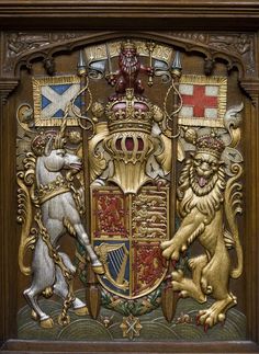 an ornate wooden plaque with two lions and a crown on it's back side