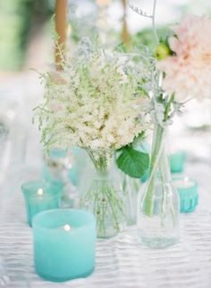 vases with flowers and candles on a table