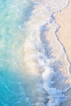 an aerial view of the ocean and beach with waves coming in from the shore,