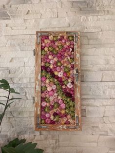 an old window is filled with flowers on the wall