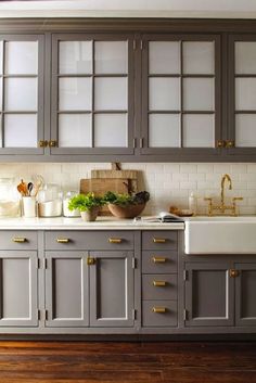 a kitchen with gray cabinets and wooden floors