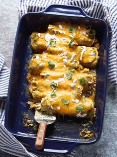 a casserole dish with chicken, cheese and cilantro sauce on top