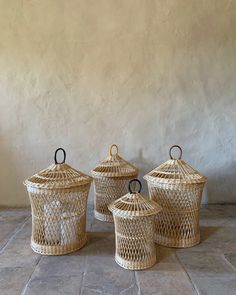 three wicker baskets sitting on top of a stone floor