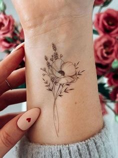 a woman's wrist with a flower tattoo on it