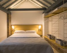 a bed sitting in a bedroom next to two lamps on either side of the bed