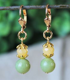 "This classic beaded necklace features beautiful yellow and olive green jade gemstones. Necklace is finished with a lobster closure. The necklace measures 18 inches in length, with 2 inches extension. This simple yet elegant pair of earrings features yellow and olive green jade gemstone drop. Hanging from a surgical steel lever-back, it measures 1.5 \" in length. Earrings are light weight and sway gracefully as you move about your day. This beautiful green and yellow necklace is unique, feminine Yellow Jade Round Jewelry, Yellow Round Jade Jewelry, Round Yellow Jade Jewelry, Elegant Lime Green Beaded Jewelry, Color Jade, Yellow Necklace, Yellow Jewelry, Jade Gemstone, Necklace Green