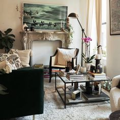 a living room filled with furniture and a fire place under a painting on the wall