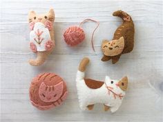 four different types of cat ornaments on a white wooden surface with text overlay that says, felt cats