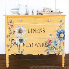 an old dresser painted with flowers and the words linens flatware written on it