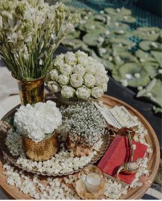 there are flowers in vases on the table with other things around it and candles