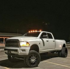 a white ram truck parked in a parking lot at night with lights on the roof