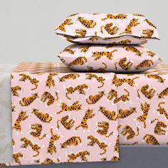 three sheets with tiger print on them stacked on top of each other in front of a gray wall