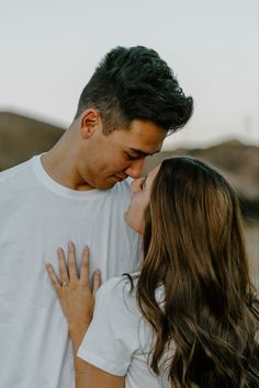 a man and woman kissing each other in the desert