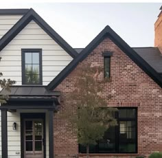 a brick house with black trim and windows