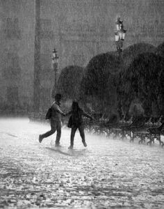 two people walking in the rain holding hands