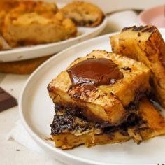 two plates with desserts on them, one has chocolate and the other has bread