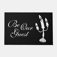 a black and white photo with the words be our guest on it, next to a candle