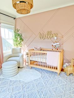 a baby's room with pink walls and white furniture