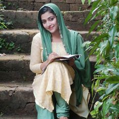 a woman sitting on steps with a book in her hand