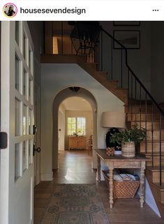 an entry way with stairs and a table on the other side in front of it