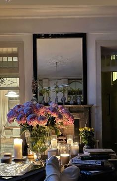 a living room filled with lots of furniture and flowers on top of a coffee table