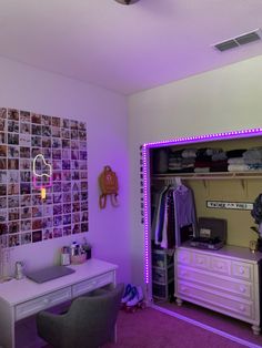 a bedroom with purple lighting and pictures on the wall above the bed, along with a desk