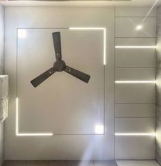 a ceiling fan mounted to the side of a wall in a room with white walls