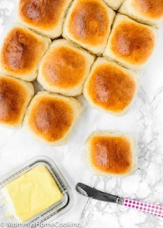 rolls and butter on a marble counter top with a baking pan next to it,