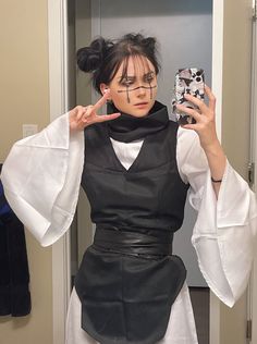 a woman is taking a selfie with her cell phone in the mirror while wearing a black and white outfit