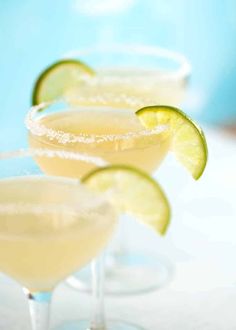 three margarita cocktails with lime and sugar garnish