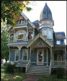 an old victorian style house with blue siding and white trim on the front porch is shown