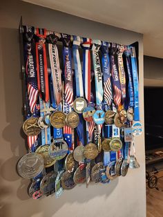 a bunch of medals are hanging on a wall