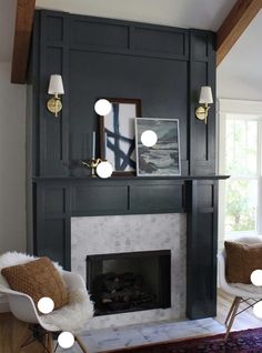 a living room with a fireplace, chairs and pictures on the wall in front of it