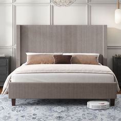 a large bed sitting on top of a blue rug next to a wall mounted clock