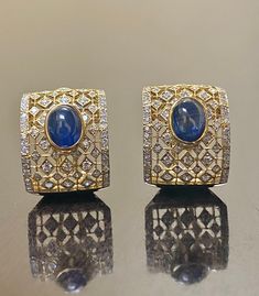 DeKara Designs Collection Metal- 18K White Gold, .750. 15.50 Grams. Stones- 2 Genuine Cabochon Oval Ceylon Blue Sapphires 5.02 Carats, 168 Round Diamonds F-G Color SI2 Clarity 2 Carats. One of a kind entirely handmade, Art Deco 18K Yellow Gold Sri Lanka Ceylon Cabochon Cut Blue Sapphire and Pave Set Diamond Art Deco Inspired One of a Kind Earrings. Each earring has an amazing oval cabochon blue sapphire that is professionally and uniquely bezel/burnish set. There are 79 round pave set diamonds o Luxury Oval Earrings For Formal Occasions, Luxury Diamond Cabochon Earrings, Luxury Diamond Earrings With Cabochon, Luxury Oval Cabochon Gemstone Earrings, Luxury Gold Oval Cabochon Earrings, Oval Sapphire Earrings With 17 Jewels, Elegant Blue Oval Cabochon Earrings, Formal Oval Sapphire Earrings, Designer Formal Gemstone Earrings