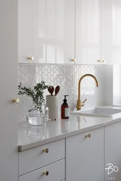 the instagram page shows an image of a kitchen with white cabinets and gold handles