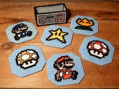 four coasters made to look like video game characters are on a wooden table next to an old radio