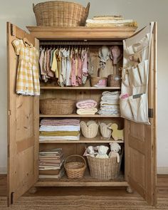 an open closet with clothes and baskets in it