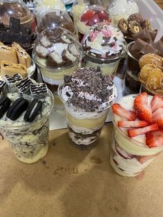 several desserts are arranged on a table with chocolate, strawberries, and cookies