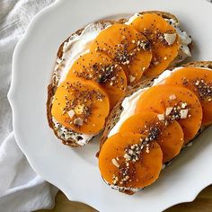 toasted bread with sliced apricots and almonds on top, sitting on a white plate